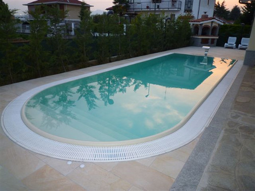piscina a sfioro con canale perimetrale e gliglia in ABS colore bianco